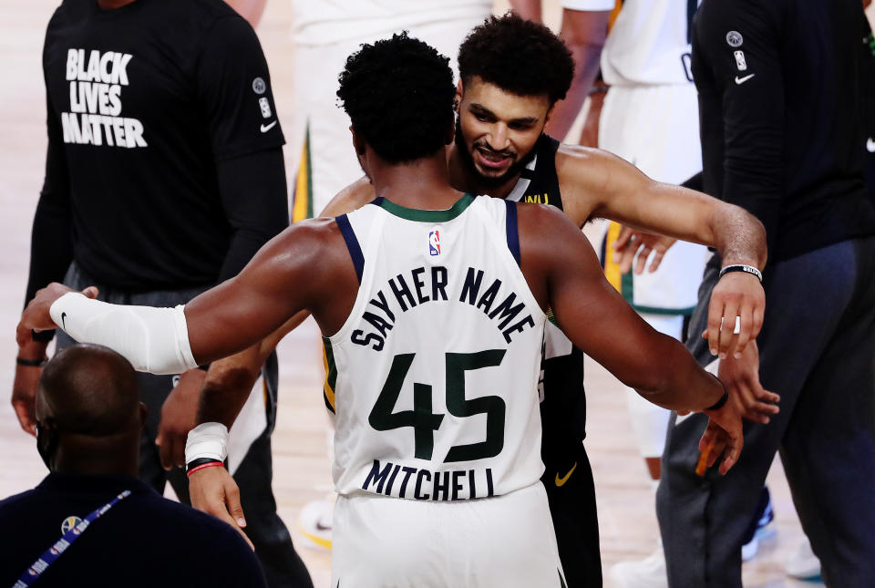 Jamal Murray and Donovan Mitchell embraced after their historic playoff duel. (Mike Ehrmann/Getty Images)