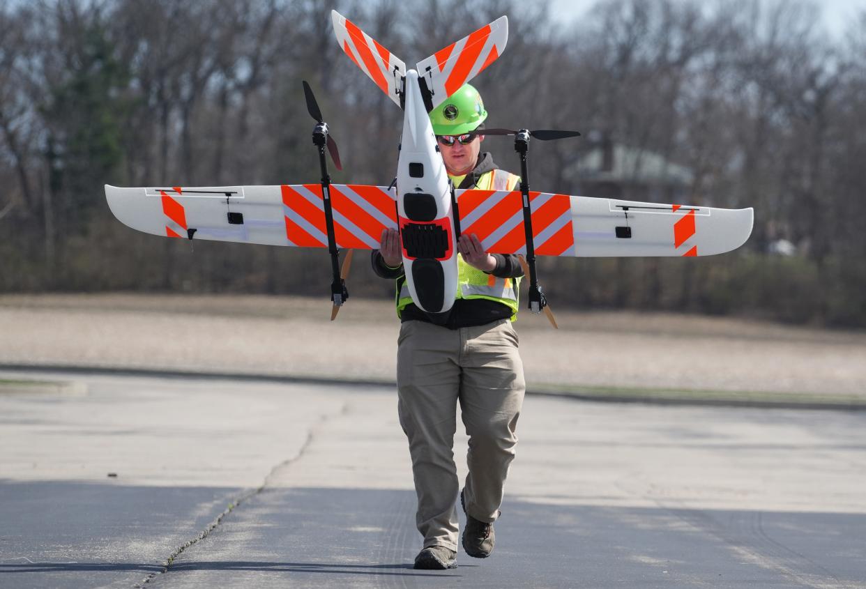 Ohio Department of Transportation chief drone pilot Daniel Kammer carries the new ODOT fixed-wind drone to a launch site on March 21, near Springfield, Ohio.