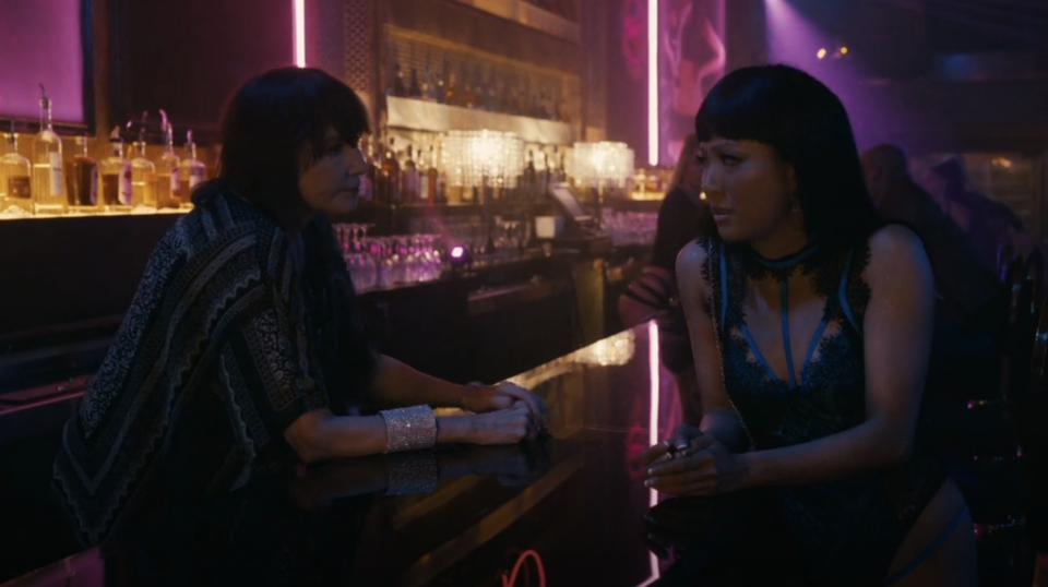 Constance Wu talking with the bartender in "Hustlers"