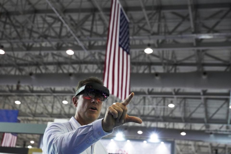 John Mathieu, the managing director of Seattle-based Taqtile Inc., uses augmented reality goggles at his stand in the American section of the Dubai Air Show in Dubai, United Arab Emirates, Tuesday, Nov. 16, 2021. The U.S. remains "fully committed" to a proposed sale of advanced F-35 stealth fighter jets to the United Arab Emirates despite the Biden administration slowing down the deal, a senior U.S. official overseeing arms exports told The Associated Press on Tuesday. (AP Photo/Jon Gambrell)