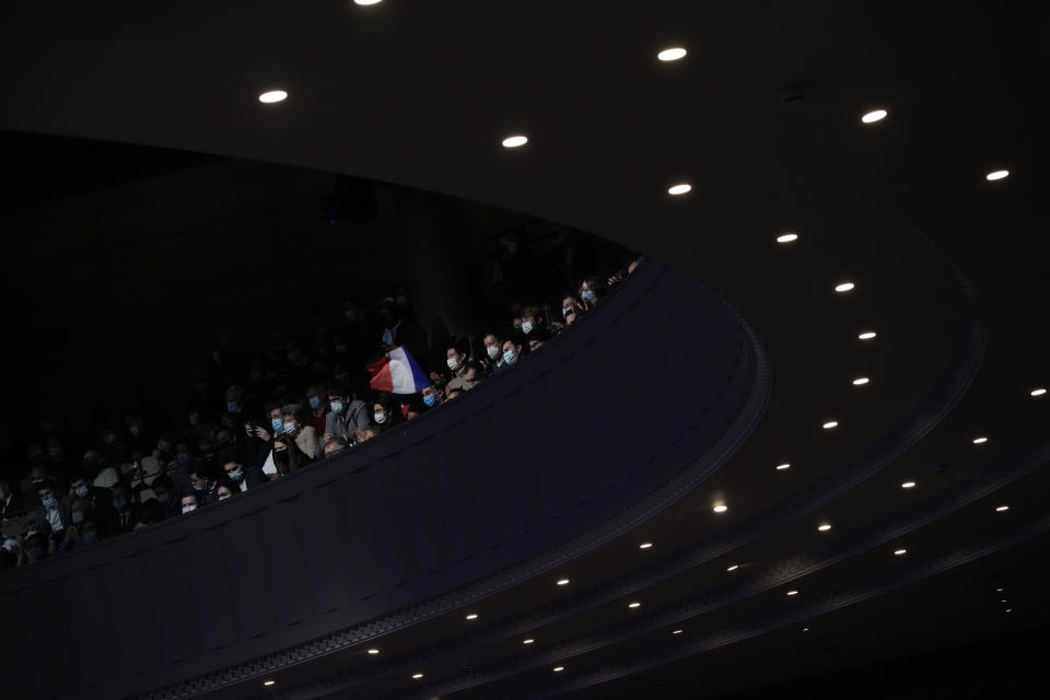 Fans wave French flags as Valerie Pecresse, candidate for the French presidential election 2022, delivers a speech during a meeting in Paris, France, Saturday, Dec. 11, 2021. The first round of the 2022 French presidential election will be held on April 10, 2022 and the second round on April 24, 2022. (AP Photo/Christophe Ena)