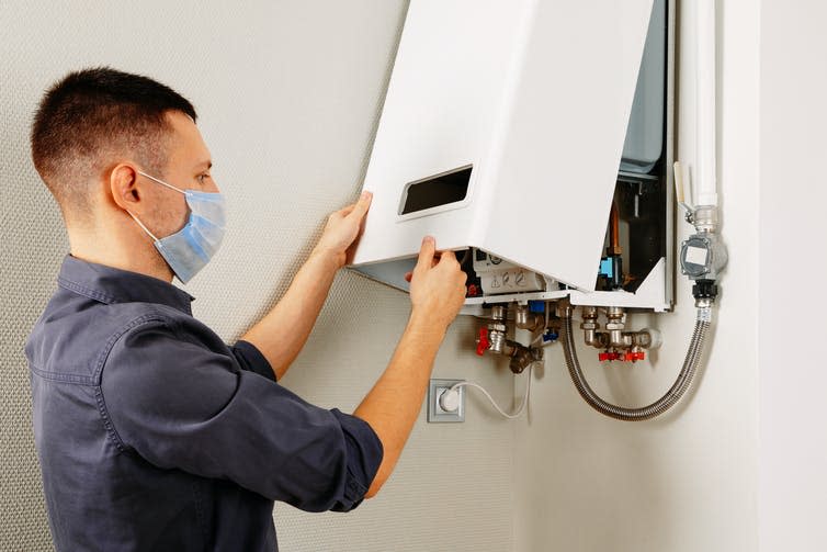 A man working on a gas boiler.