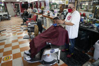 Edgar Gomez has his hair cut by George Garcia, owner of George's Barber Shop, Tuesday, July 14, 2020, in San Pedro, Calif. Gov. Gavin Newsom ordered that indoor businesses like salons, barber shops, restaurants, movie theaters, museums and others close due to the spread of COVID-19. (AP Photo/Ashley Landis)