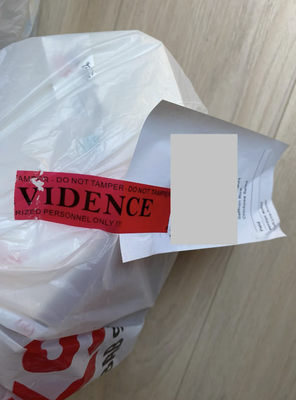 A red and white evidence bag with a tamper-proof seal and a partially visible document