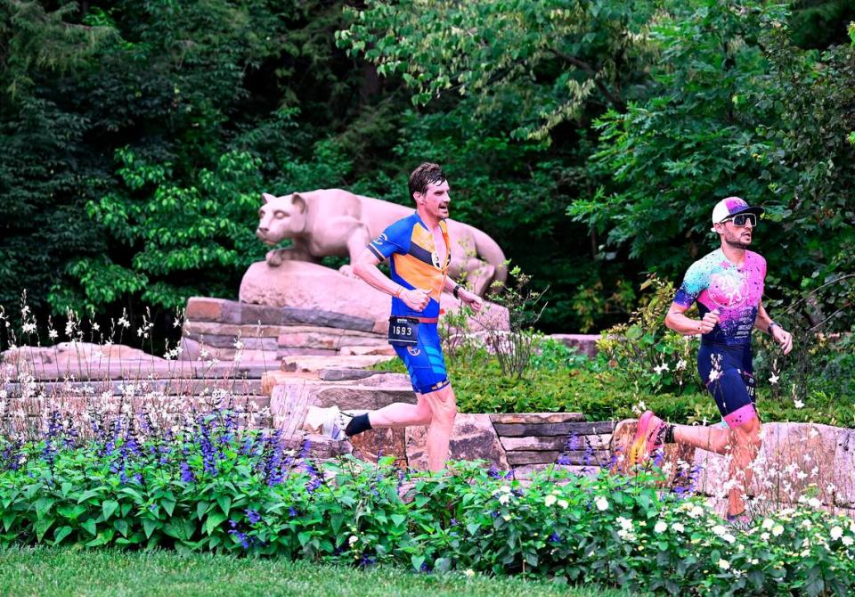 Participants in the Ironman 70.3 Pennsylvania Happy Valley run past the Nittany Lion Shrine on the Penn State campus Sunday, July 2, 2023. Steve Manuel/For the CDT