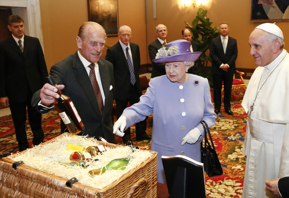 Britain's Queen Elizabeth II and Prince Philip, Duke of Edinburgh, exchange gifts with Pope Francis at the Vatican, Thursday, April 3, 2014. Queen Elizabeth II has come to Rome for lunch with Italy's president Giorgio Napolitano ahead of the British monarch's first meeting with Pope Francis. Before Francis, Elizabeth had met with four pontiffs, starting with Pope Pius XII in 1951, a year before her accession to the throne. (AP Photo/Stefano Rellandini, Pool)