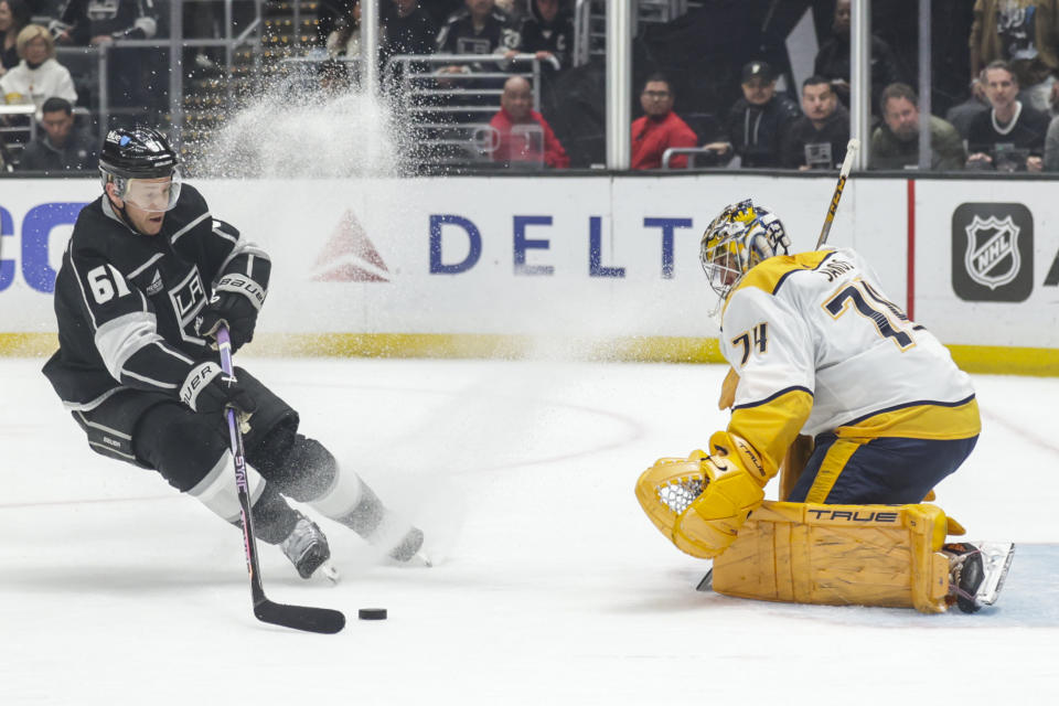 Los Angeles Kings center Trevor Lewis (61) moves in on Nashville Predators goalie Juuse Saros (74) during the second period of an NHL hockey game Thursday, Feb. 22, 2024, in Los Angeles. (AP Photo/Yannick Peterhans)