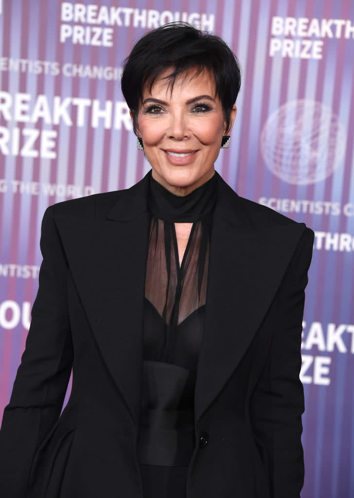 Kris Jenner posing in a black suit with sheer detailing at the Breakthrough Prize event