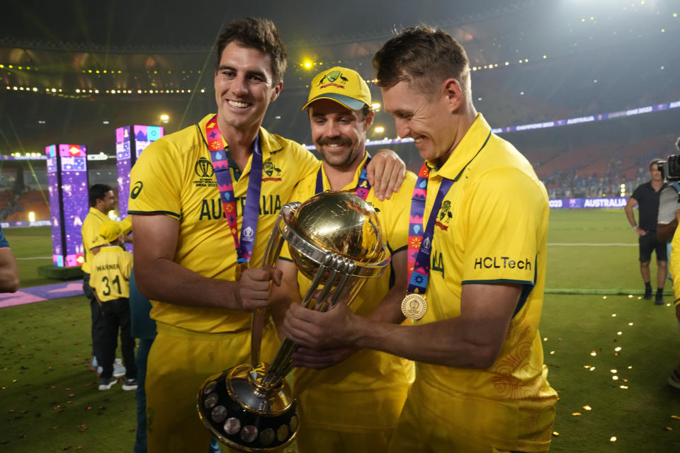 Australia's captain Pat Cummins, Australia's Travis Head and Marnus Labuschagne pose with the trophy after wining the ICC Men's Cricket World Cup final match against India in Ahmedabad, India, Sunday, Nov.19, 2023. (AP Photo/Aijaz Rahi)