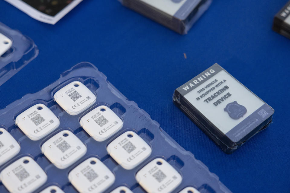 Mobile tracking devices and stickers from the Metropolitan Police Department are seen on a table during an event where police officers distributed Apple AirTags and similar tracking devices to drivers in an attempt to curb a rise in crime in Washington on Tuesday, Nov. 7, 2023. (AP Photo/Amanda Andrade-Rhoades)