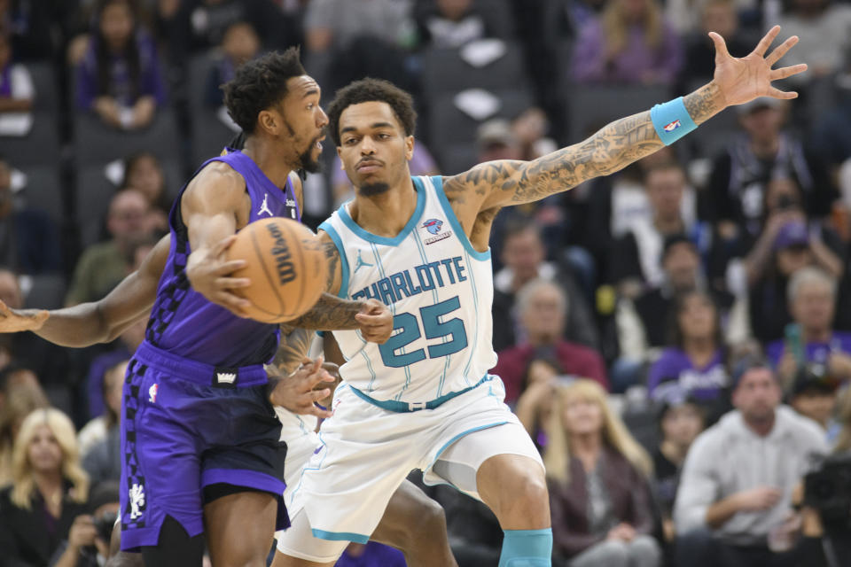 Sacramento Kings guard Malik Monk, left, is guarded by Charlotte Hornets forward P.J. Washington (25) during the first quarter of an NBA basketball game in Sacramento, Calif., Tuesday, Jan. 2, 2024. (AP Photo/Randall Benton)