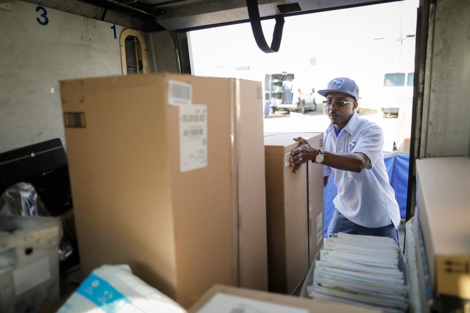 Mail carrier Edward Medley, of Groveport, Ohio, loads his delivery truck with mail and packages earlier this year. The postal service is seeking to slow down an increase it has seen in mail theft and robberies of mail carriers.