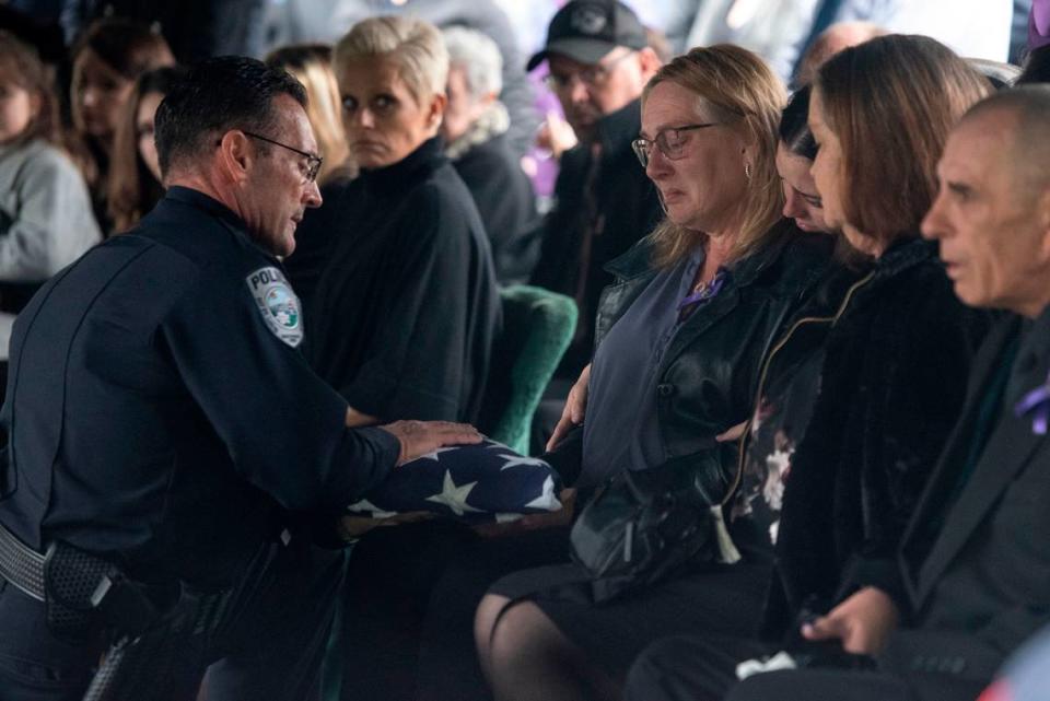 Bay St. Louis Police Chief Toby Schwartz presents a folded flag to Steven Robin’s wife Amy Robin during the funeral of Bay St. Louis police officers Sgt. Steven Robin and Branden Estorffe at Gardens of Memory cemetery in Bay St. Louis on Wednesday, Dec. 21, 2022. Robin and Estorffe were killed responding to a call at a Motel 6 on Dec. 14.