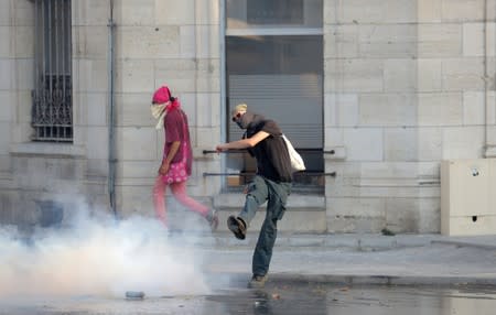 A demonstrator kicks a gas canister at a protest during the G7 summit, in Bayonne