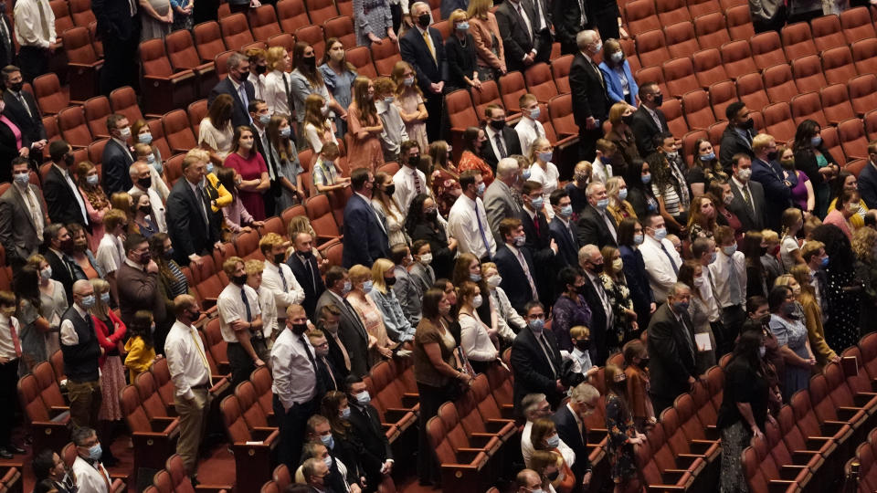 People attend The Church of Jesus Christ of Latter-day Saints' twice-annual church conference Saturday, Oct. 2, 2021, in Salt Lake City. The Utah-based faith has repeatedly encouraged its 16 million members worldwide to limit the spread by getting vaccines and wearing masks. The conference is taking place again without full attendance due to the pandemic. For the first time in two years, though, leaders were back at the faith's 20,000-seat conference center, with several hundred people watching in person. (AP Photo/Rick Bowmer)