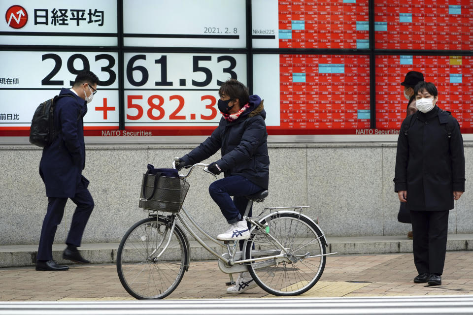 An electronic stock board showing Japan's Nikkei 225 index at a securities firm is seen at a street Monday, Feb. 8, 2021, in Tokyo. Asian shares mostly rose Monday, tracking a rally on Wall Street last week, with Japan's benchmark momentarily reaching three-decade highs, on growing optimism about the global economy.(AP Photo/Eugene Hoshiko)