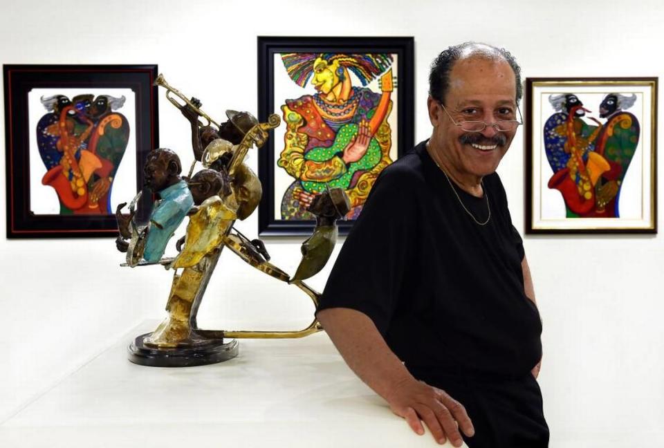 Ed Dwight in 2016, with his bronze sculpture on display at the American Jazz Museum. Behind Dwight are the paintings of Charles Biggs. Rich Sugg/The Kansas City Star