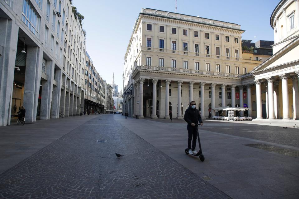 A man wearing a mask rides a scooter in Milan, Italy,  March 11, 2020. Italy is mulling even tighter restrictions on daily life and has announced billions in financial relief to cushion economic shocks from the coronavirus. 