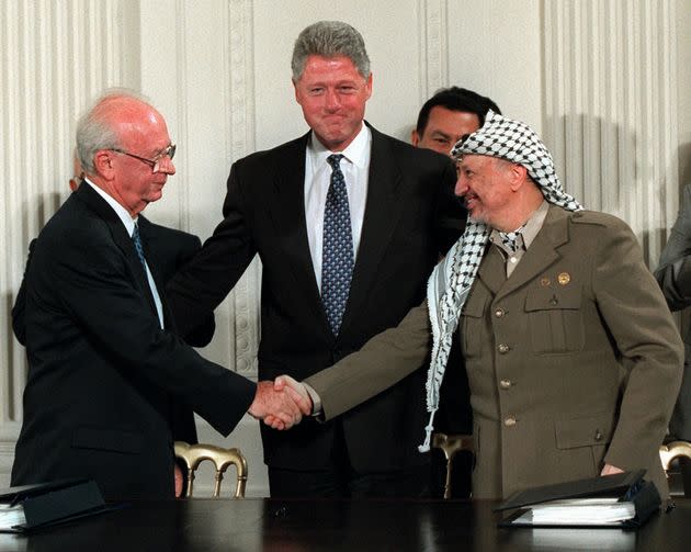 FILE - Sept. 28, 1995 file photo shows President Bill Clinton gesturing toward Israeli Prime Minister Yitzhak Rabin, left, and PLO leader Yasser Arafat shaking hands in the East Room of the White House after the Mideast accord signing.