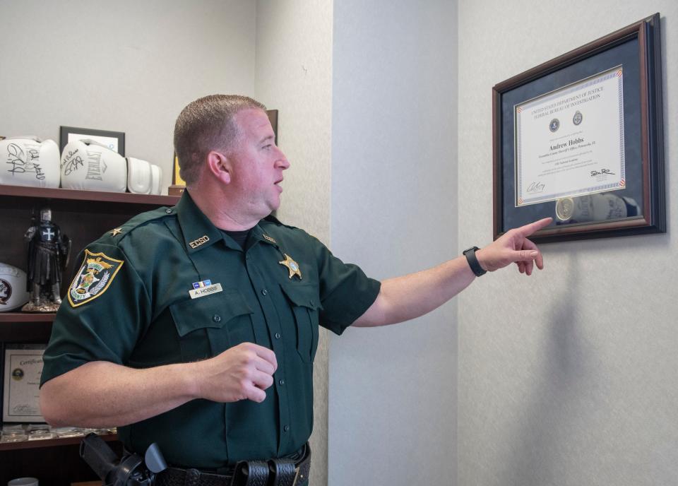 Cmdr. Andrew Hobbs points out his FBI National Academy certificate on display in his office at the Escambia County Sheriff's Office in Pensacola on Thursday, June 30, 2022.