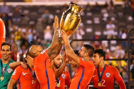 Jun 26, 2016; East Rutherford, NJ, USA; Chile midfielder Arturo Vidal (8) and Chile defender Mauricio Isla (4) hoist the championship trophy after winning the championship match of the 2016 Copa America Centenario soccer tournament against Argentina at MetLife Stadium. Chile defeated Argentina 0-0 (4-2). Mandatory Credit: Brad Penner-USA TODAY Sports