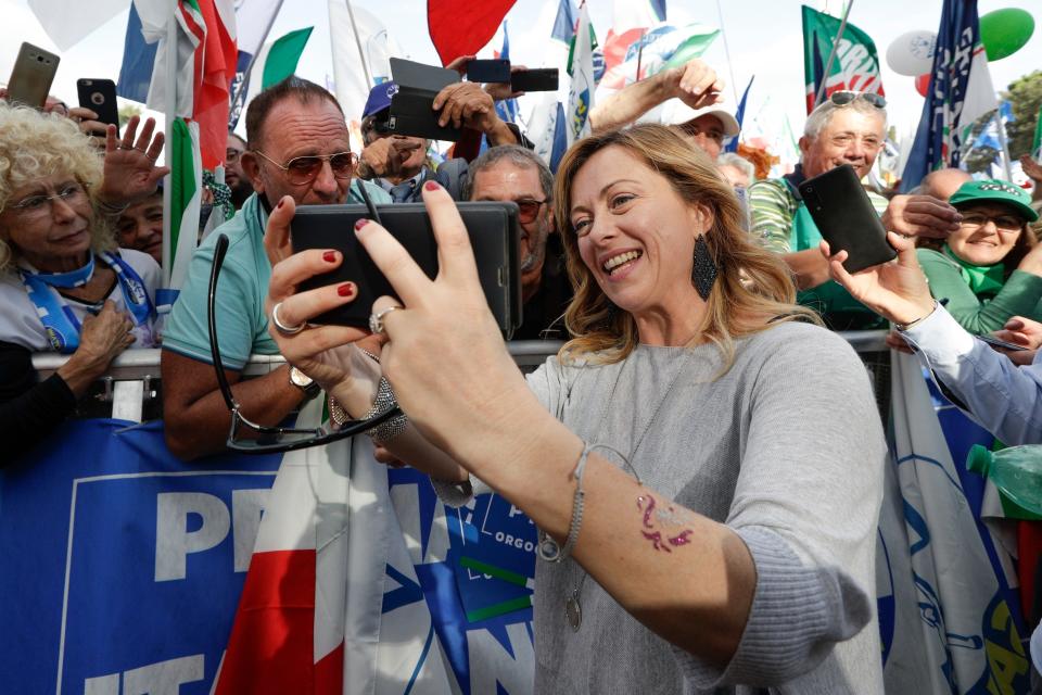 FILE — Brothers of Italy's party leader, Giorgia Meloni, takes a selfie with supporters during a rally in Rome, Saturday, Oct. 19, 2019. With God, homeland and &quot;natural&quot; family prominent in her political manifesto, Giorgia Meloni, whose Fratelli d'Italia (Brothers of Italy) party with neo-fascist roots has been fast rising in popularity in view of the upcoming Sept. 25 elections for Parliament, is positioning herself to become Italy's first far-right premier and the first woman to hold that office. (AP Photo/Andrew Medichini) ORG XMIT: rom103