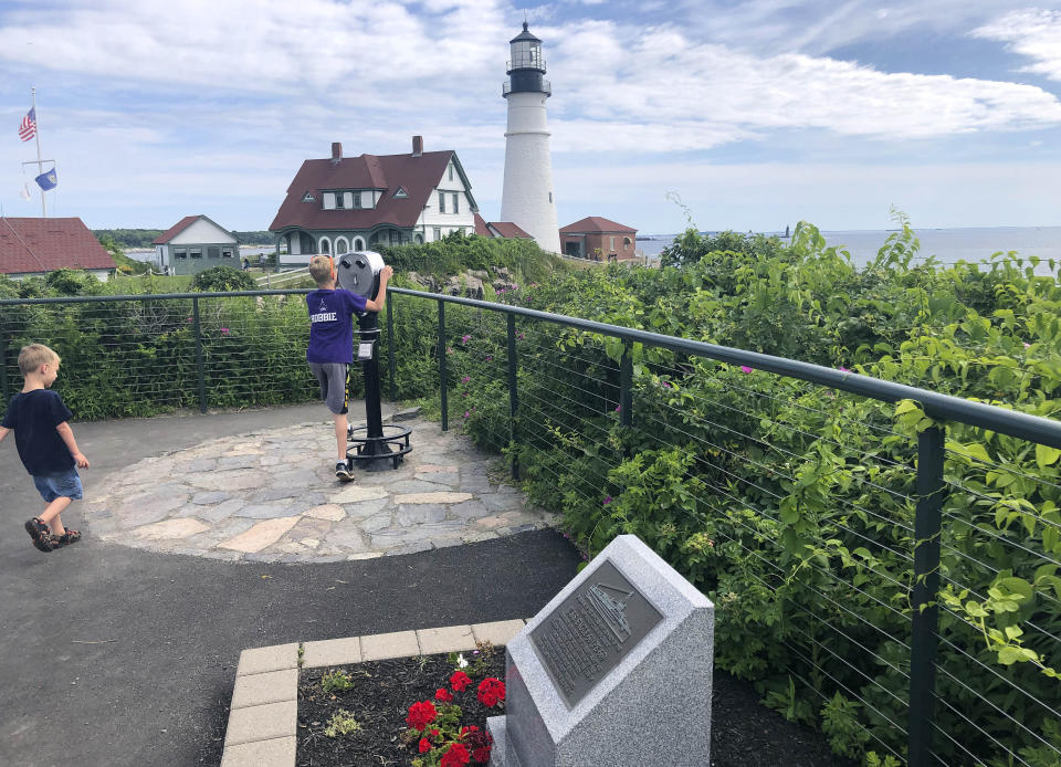 Children take in the view at Fort Williams Park at Cape Elizabeth, Maine, on Thursday, July 18, 2019, where a plaque, foreground, remembers those killed when the USS Eagle PE-56 was sunk During World War II off the Maine coast on April 23, 1945. The Navy determined in 2001 that the patrol boat had been sunk by a German submarine. On Monday, July 15, 2019, Garry Kozak, a specialist in undersea searches, announced that Ryan King, a New Hampshire diver, located the vessel’s bow and stern about three miles off Cape Elizabeth in June 2018. (AP Photo/David Sharp)