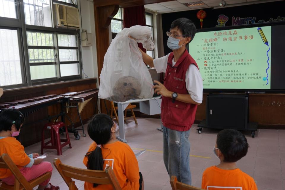 獸醫師王嚴緒正在介紹2天前剛摘除的熱騰騰虎頭蜂窩。   圖：新北市動保處提供