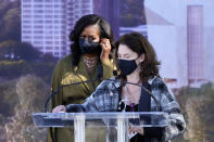 Michelle Breger sanitizes the podium after the previous speaker, as former first lady Michelle Obama approaches it to speak during a groundbreaking ceremony for the Obama Presidential Center Tuesday, Sept. 28, 2021, in Chicago. (AP Photo/Charles Rex Arbogast)