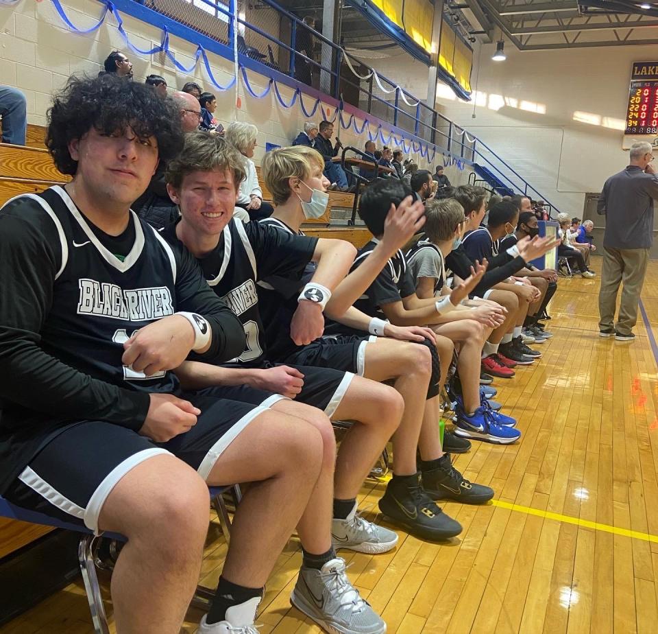 Members of the Black River JV boys basketball team show their "JS" armbands worn Tuesday, March 1, in honor of their late coach Joe Schuler.