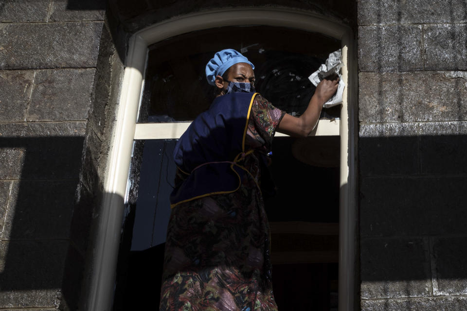 A woman cleans the window of a house in the capital Addis Ababa, Ethiopia Friday, Nov. 13, 2020. Tensions over the deadly conflict in Ethiopia are spreading well beyond its cut-off northern Tigray region, as the federal government said some 150 suspected "operatives" accused of seeking to "strike fear and terror" throughout the country had been detained. (AP Photo/Mulugeta Ayene)
