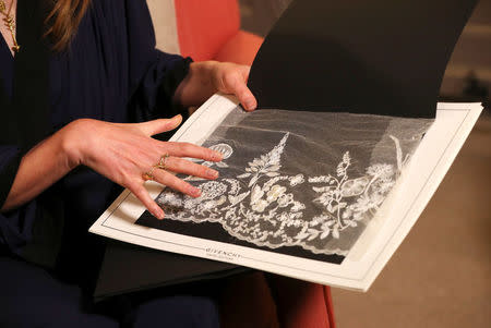 Clare Waight Keller, designer at Givenchy, holds lace as she gives an interview the day after Meghan Markle walked down the aisle of St George's Chapel in Windsor and married Prince Harry wearing the dress that she created, in Kensington Palace, London, Britain, May 20, 2018. REUTERS/Hannah McKay/Pool