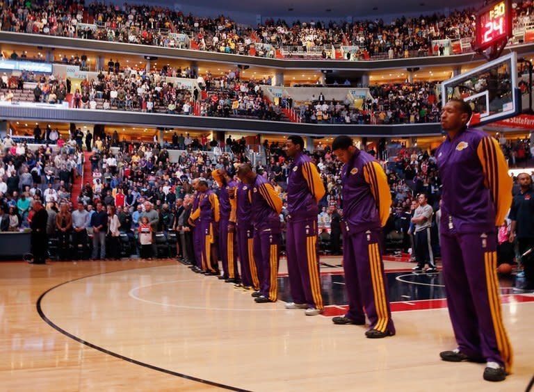 The Los Angeles Lakers and the crowd observe a moment of silence for victims of a mass school shooting in Newtown, Connecticut, before the start of their game against the Washington Wizards at Verizon Center on December 14, 2012. World leaders expressed shock and horror after a gunman massacred 20 small children and six teachers, in one of the worst school shootings in history