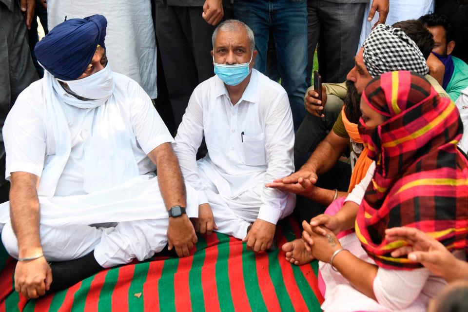 President Sukhbir Singh Badal (L) listens to the relatives of Paramjeet Singh who died after allegedly drinking spurious alcohol (AFP via Getty Images)