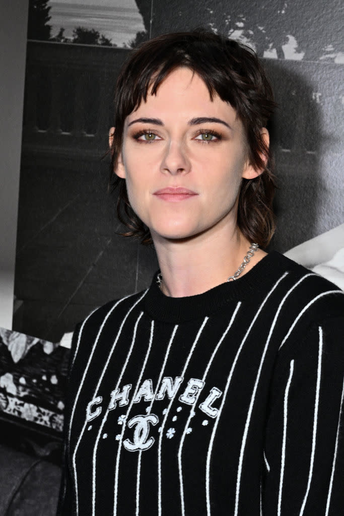 Kristen with short hair poses for the camera in a striped Chanel top