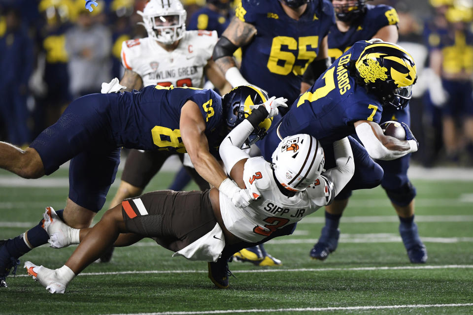Michigan running back Donovan Edwards (7) dives for yardage as he is tackled by Bowling Green linebacker Joseph Sipp Jr. (3) in the first quarter of an NCAA college football game, Saturday, Sept. 16, 2023, in Ann Arbor, Mich. (AP Photo/Jose Juarez)
