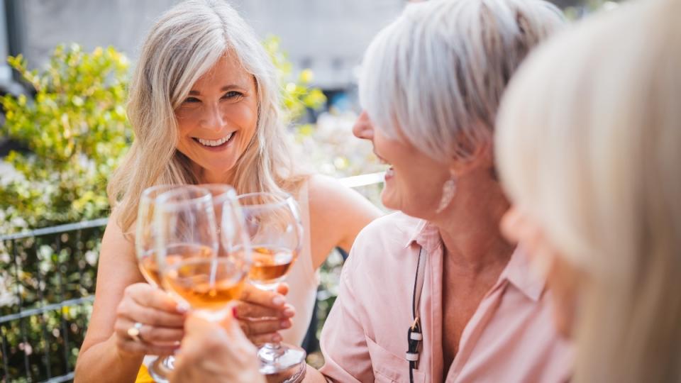 Three women with glasses of wine, which wards off osteoporosis