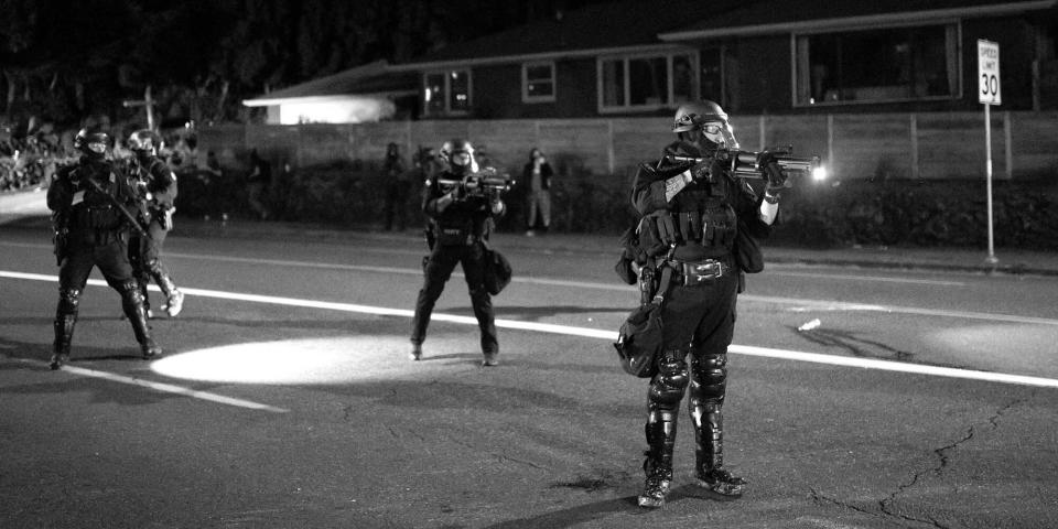 A Portland police officer points a less-lethal weapon at anti-police protesters a day after political violence left one person dead, on Aug. 30, 2020, in Portland, Oregon. (Photo: Photo:Nathan Howard/Getty Images)