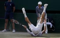 Milos Raonic of Canada falls during his men's singles semi-final tennis match against Roger Federer of Switzerland at the Wimbledon Tennis Championships, in London July 4, 2014. REUTERS/Suzanne Plunkett (BRITAIN - Tags: SPORT TENNIS)