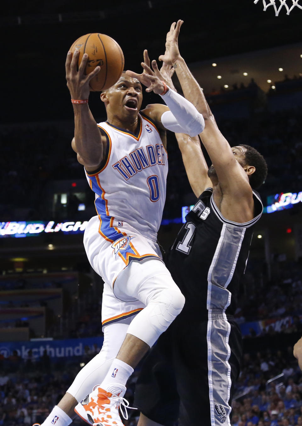 Oklahoma City Thunder guard Russell Westbrook (0) goes up to shoot as San Antonio Spurs forward Tim Duncan defends during the first quarter of an NBA basketball game in Oklahoma City, Thursday, April 3, 2014. (AP Photo/Sue Ogrocki)