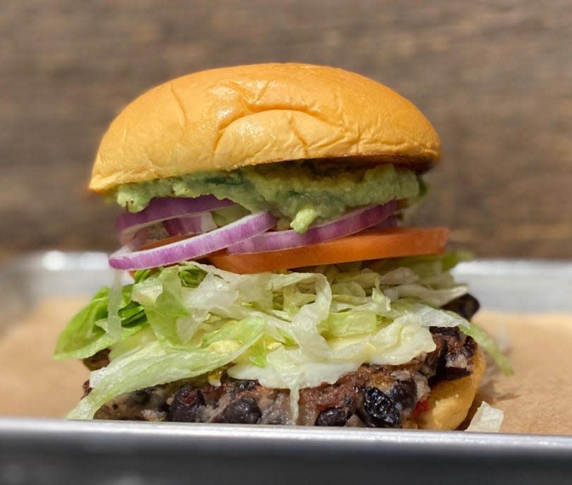 Mac & Walt’s “Where’s The Beef” burger is a house-made black bean burger, served with lettuce, tomato, onion, guacamole, and pepper jack cheese.