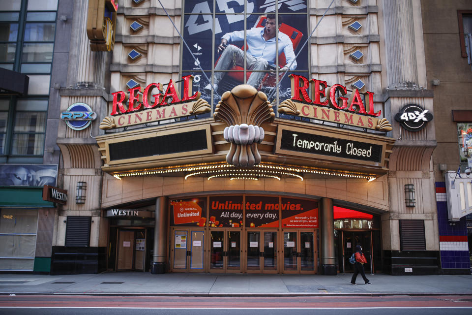 En esta foto del 21 de marzo del 2020, una persona con una mascarilla protectora debido a la pandemia del COVID-19 pasa frente a un cine cerrado en Nueva York. Con los cines cerrados, los amigos han encontrado la manera de ver películas juntos en su aislamiento gracias a aplicaciones como Netflix Party. (AP Foto/John Minchillo, Archivo)