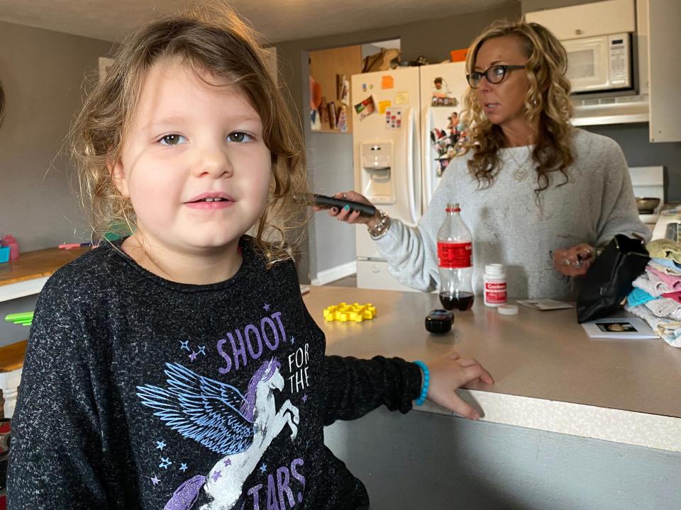 Zyla Cozza, 5, pauses for a moment after a morning of constant motion at the home of her great-aunt and child care provider, Wendy Tilma (standing).