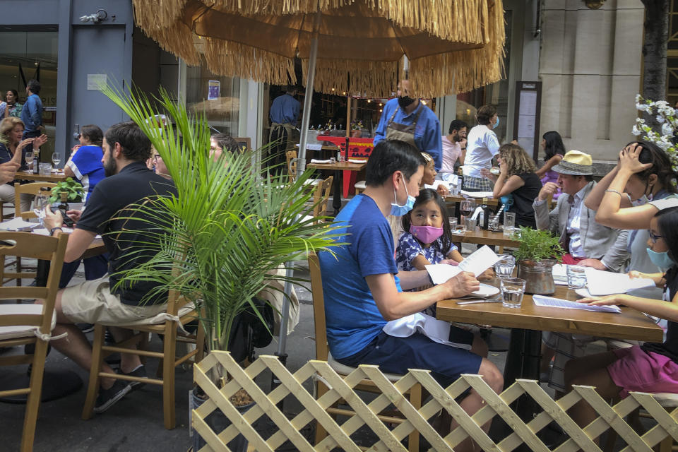 Diners eat al fresco due to COVID-19 concerns in midtown Manhattan, Friday, June 26, 2020, in New York. New York City Mayor Bill de Blasio says he's delaying the planned resumption of indoor dining at restaurants in the city out of fear it would ignite a spike in coronavirus infections. (AP Photo/John Minchillo)