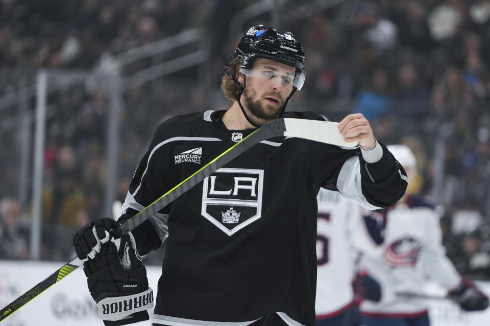 Los Angeles Kings right wing Adrian Kempe checks his tape during the first period of the team's NHL hockey game against the Columbus Blue Jackets, Tuesday, Feb. 20, 2024, in Los Angeles. (AP Photo/Ryan Sun)