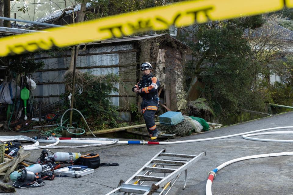 Firefighters investigate a partly burned and collapsed house (Getty Images)