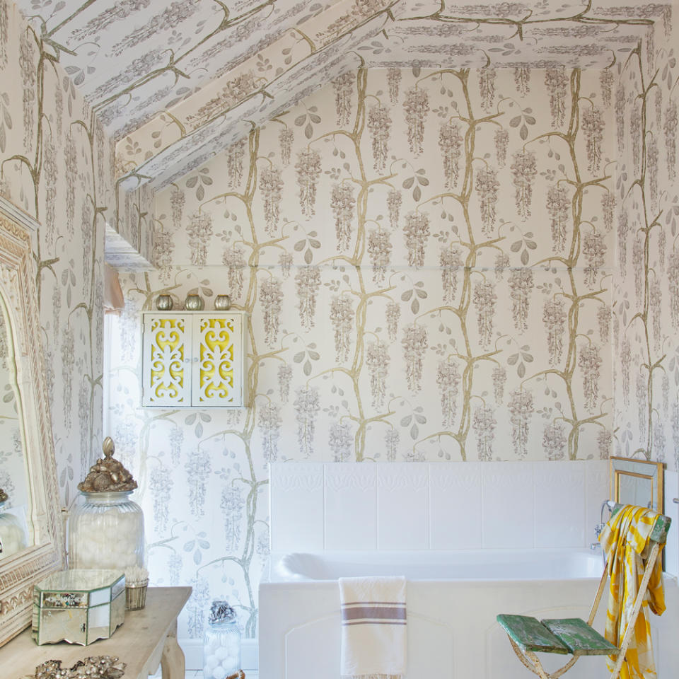 attic bedroom with white bathtub and angled ceiling