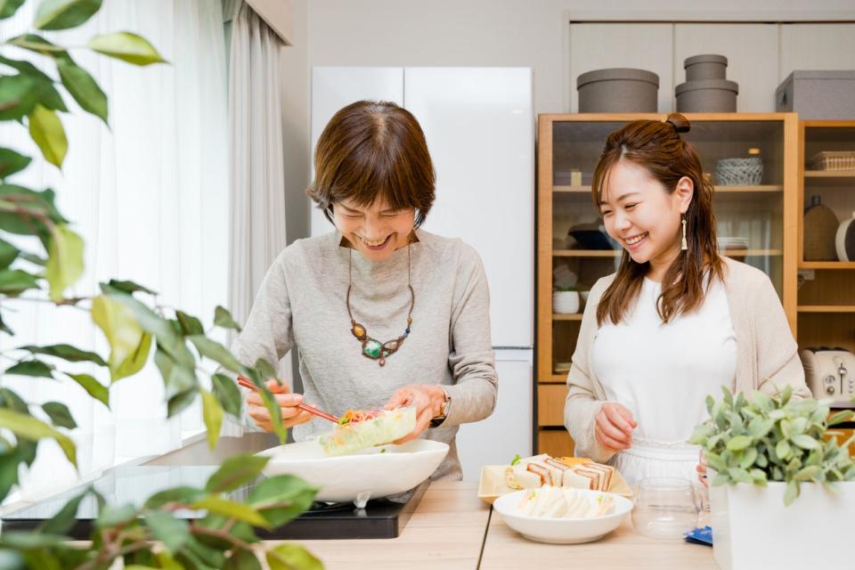 Mother and daughter who serve a sandwich in the kitchen