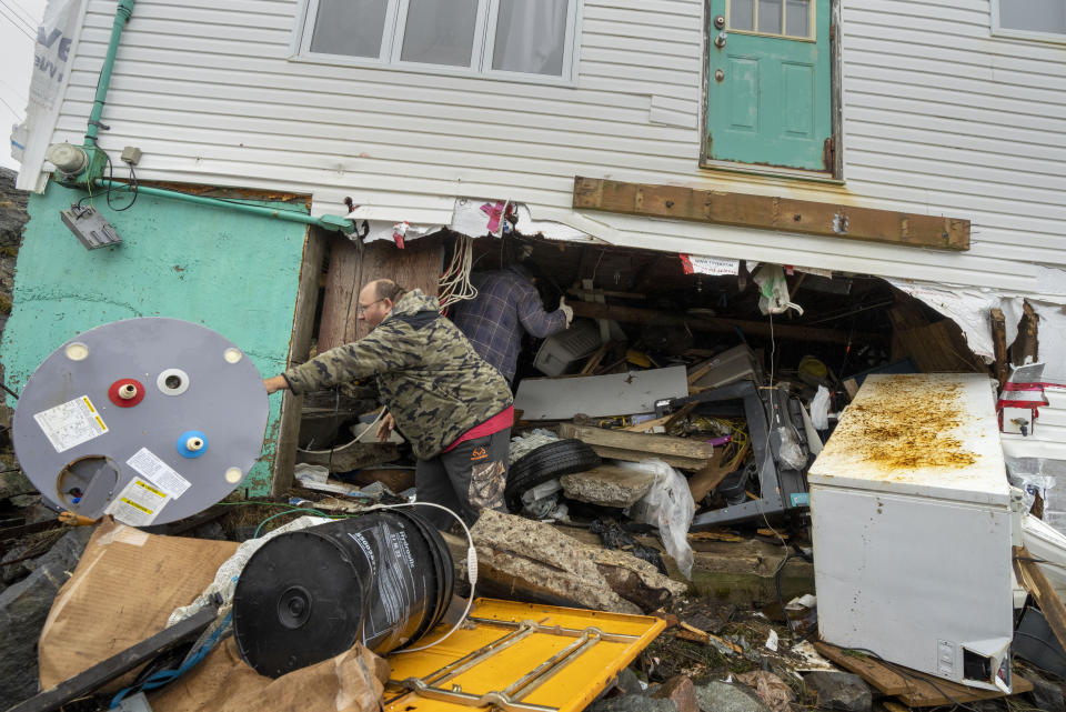 Jamie King clears out the rubble and belongings from the washed out foundation and basement of his house in Burnt Island, Newfoundland and Labrador on Tuesday Sept. 27, 2022. Fiona left a trail of destruction across much of Atlantic Canada, stretching from Nova Scotia's eastern mainland to Cape Breton, Prince Edward Island and southwestern Newfoundland. (Frank Gunn /The Canadian Press via AP)