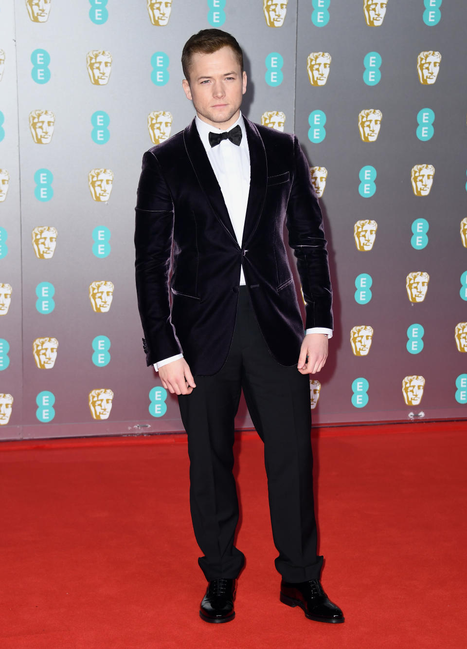 Taron Egerton looked dapper in a plum-hued velvet suit jacket